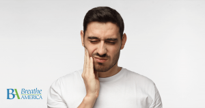 a man rubbing his jaw in pain