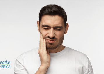 a man rubbing his jaw in pain